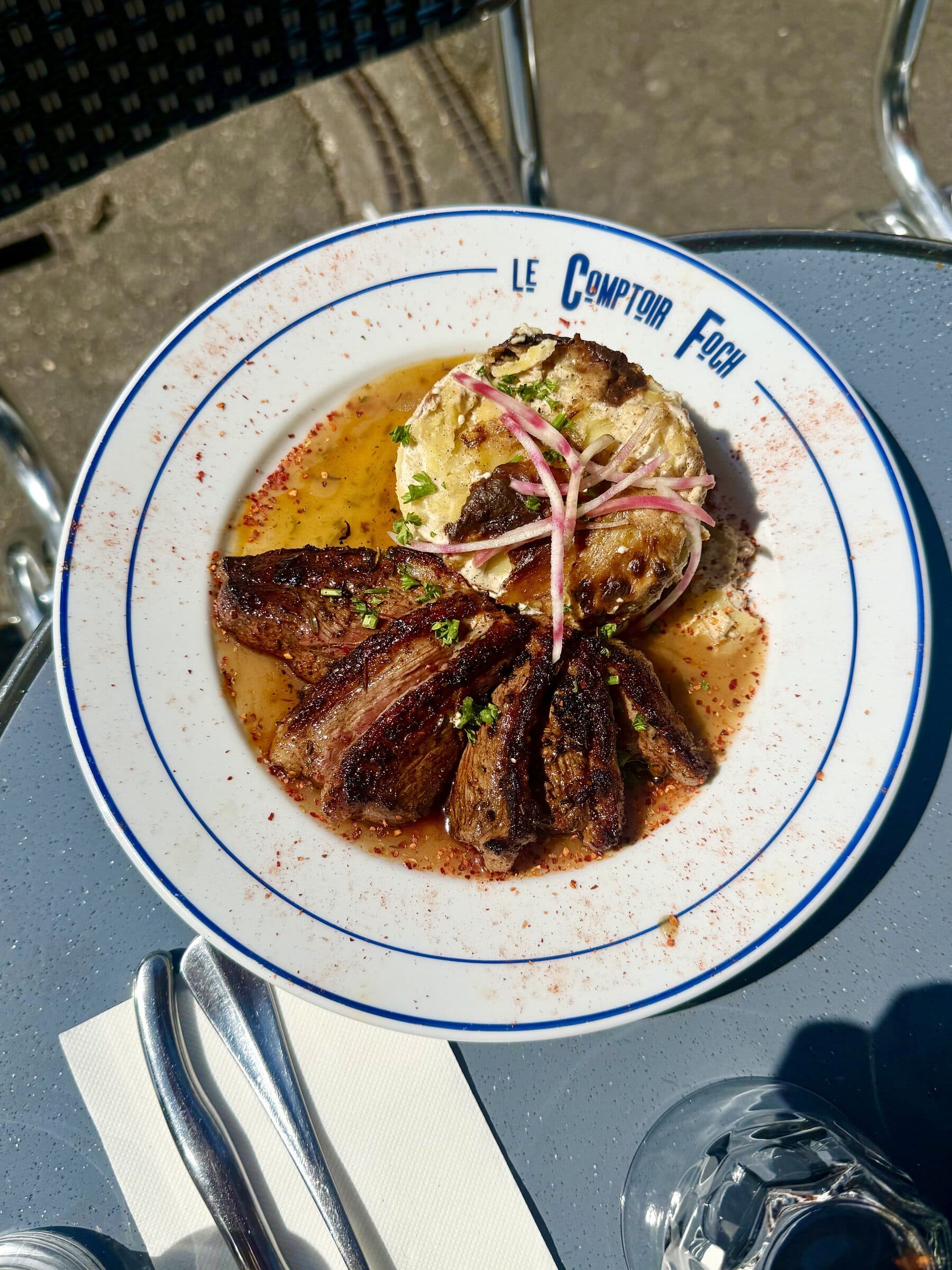 Tranches de magret de canard grillé et pomme de terre rôtie sur assiette Le Comptoir Foch, table de terrasse